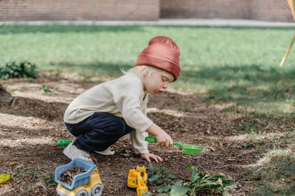 small child digging up mud