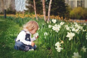 child smelling flowers